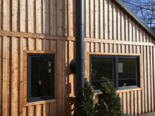 Drevená budova s antracitovými plastovými oknami